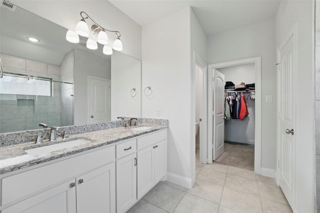 2109 Liriope Ln, Waxahachie, TX 75165 - full bath with double vanity, a shower stall, baseboards, a spacious closet, and tile patterned floors