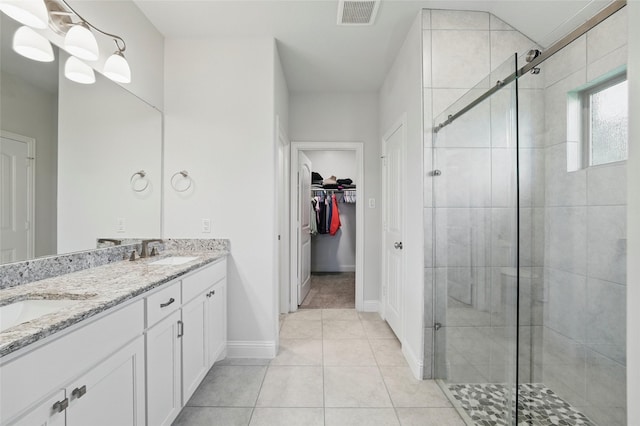 2109 Liriope Ln, Waxahachie, TX 75165 - full bathroom with a stall shower, double vanity, tile patterned flooring, a spacious closet, and baseboards