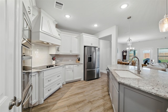 2109 Liriope Ln, Waxahachie, TX 75165 - kitchen featuring appliances with stainless steel finishes, a sink, tasteful backsplash, white cabinets, and pendant lighting