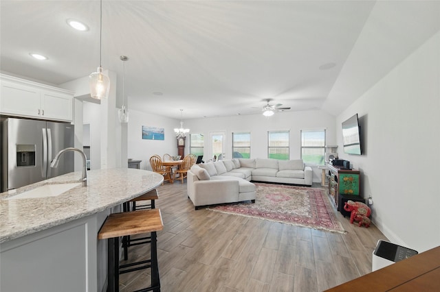 2109 Liriope Ln, Waxahachie, TX 75165 - living room featuring light wood-style flooring, ceiling fan, a chandelier, baseboards, and recessed lighting