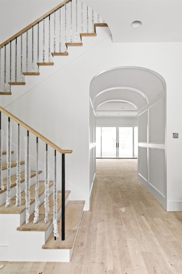 6207 Marquita Ave, Dallas, TX 75214 - stairway with arched walkways, hardwood / wood-style flooring, and baseboards