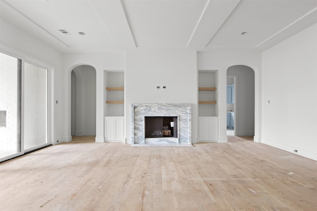 6207 Marquita Ave, Dallas, TX 75214 - unfurnished living room with built in shelves, arched walkways, wood finished floors, and baseboards