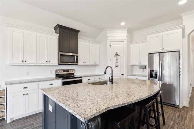 900 E 5th St, Springtown, TX 76082 - kitchen featuring stainless steel appliances, a sink, a breakfast bar, white cabinetry, and recessed lighting