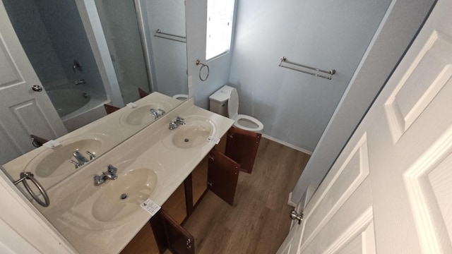 5833 Mirror Ridge Dr, Fort Worth, TX 76179 - bathroom featuring wood finished floors, double vanity, toilet, shower / washtub combination, and baseboards