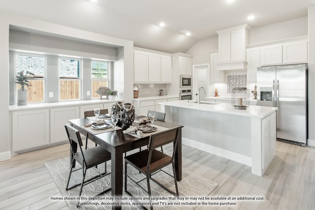924 Split Oak Ln, Anna, TX 75409 - kitchen featuring appliances with stainless steel finishes, a sink, decorative backsplash, light countertops, and light wood-style floors