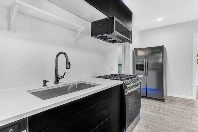 2735 Grafton Ave, Dallas, TX 75211 - kitchen featuring stainless steel appliances, dark cabinetry, light countertops, modern cabinets, and light wood-style flooring