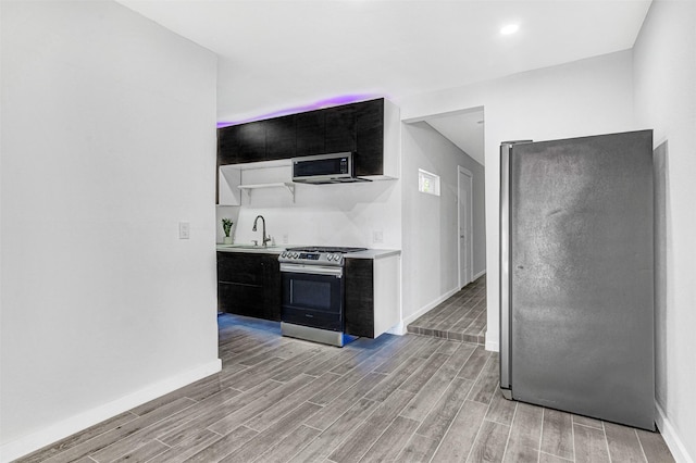 2735 Grafton Ave, Dallas, TX 75211 - kitchen with appliances with stainless steel finishes, light wood finished floors, light countertops, and dark cabinetry