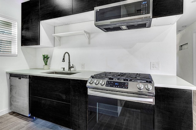 2735 Grafton Ave, Dallas, TX 75211 - kitchen with appliances with stainless steel finishes, dark cabinetry, modern cabinets, light countertops, and light wood-type flooring