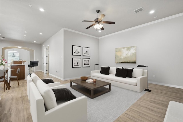 2460 Sunderland Ln, Lewisville, TX 75067 - living area featuring arched walkways, ceiling fan, light wood-style floors, baseboards, and recessed lighting