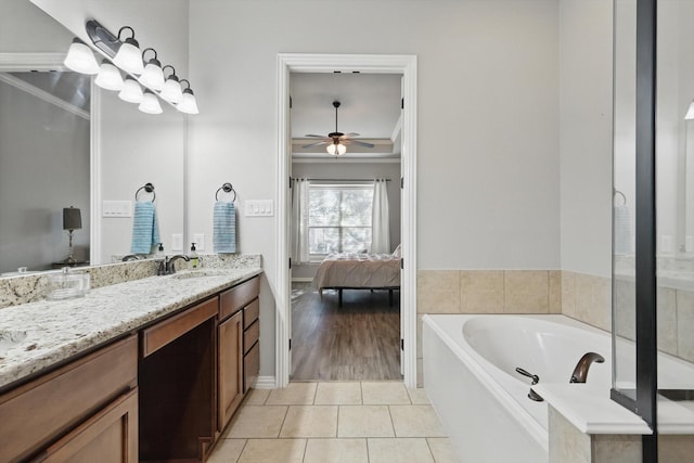2460 Sunderland Ln, Lewisville, TX 75067 - ensuite bathroom featuring a ceiling fan, vanity, a garden tub, tile patterned flooring, and ornamental molding