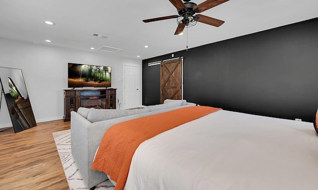 1835 Fort Graham Rd, Waco, TX 76705 - bedroom with a barn door, light wood-type flooring, recessed lighting, baseboards, and a ceiling fan