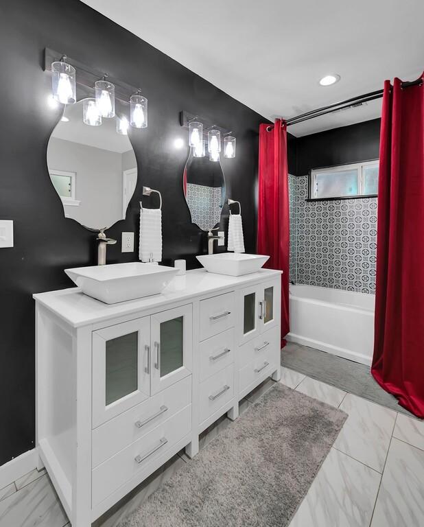 1835 Fort Graham Rd, Waco, TX 76705 - bathroom featuring double vanity, shower / tub combo, and marble look tiles