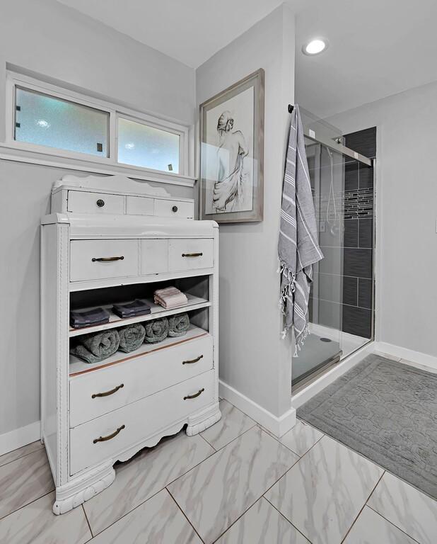 1835 Fort Graham Rd, Waco, TX 76705 - full bathroom with a stall shower, baseboards, and marble finish flooring