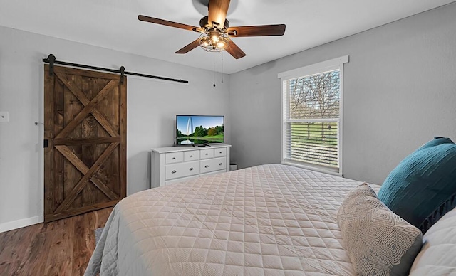 1835 Fort Graham Rd, Waco, TX 76705 - bedroom with a barn door, wood finished floors, baseboards, and a ceiling fan