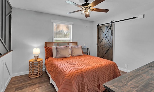 1835 Fort Graham Rd, Waco, TX 76705 - bedroom featuring a barn door, wood finished floors, baseboards, and a ceiling fan