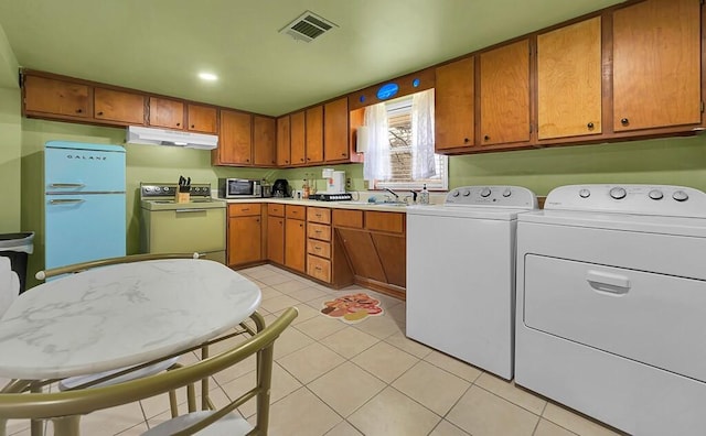1835 Fort Graham Rd, Waco, TX 76705 - kitchen with white electric stove, refrigerator, under cabinet range hood, washing machine and clothes dryer, and light tile patterned flooring