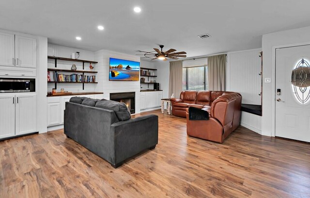 1835 Fort Graham Rd, Waco, TX 76705 - living area with a ceiling fan, wood finished floors, a warm lit fireplace, and recessed lighting