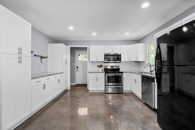 2915 Ethel Ave, Waco, TX 76707 - kitchen featuring appliances with stainless steel finishes, finished concrete floors, backsplash, a sink, and plenty of natural light