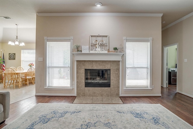 320 Westgate Dr, Aledo, TX 76008 - living area featuring a chandelier, wood finished floors, crown molding, a tiled fireplace, and baseboards