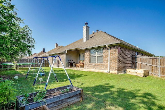 320 Westgate Dr, Aledo, TX 76008 - rear view of house with a trampoline, a vegetable garden, a playground, and brick siding