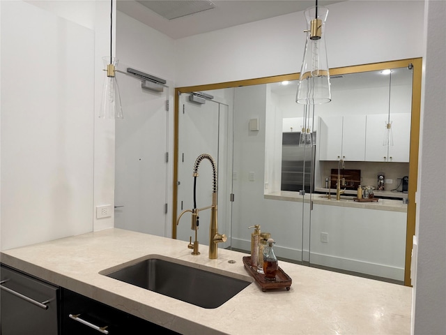 2200 Victory Ave Unit 2306, Dallas, TX 75219 - kitchen featuring a sink, stainless steel appliances, white cabinetry, light countertops, and pendant lighting