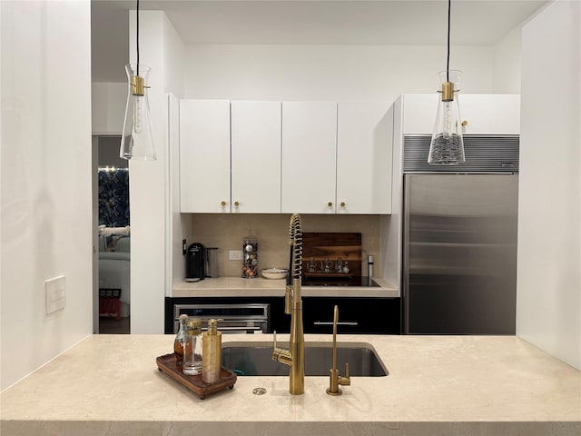 2200 Victory Ave Unit 2306, Dallas, TX 75219 - kitchen featuring built in fridge, light countertops, white cabinetry, a sink, and decorative light fixtures