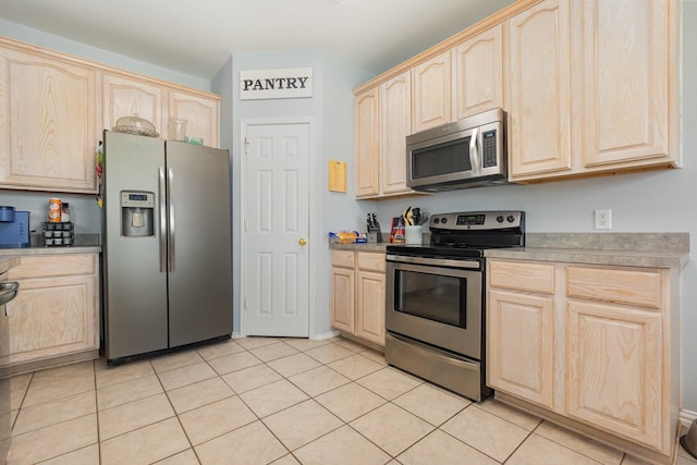 2344 Magnolia Dr, Little Elm, TX 75068 - kitchen featuring appliances with stainless steel finishes, light brown cabinets, light tile patterned flooring, and light countertops