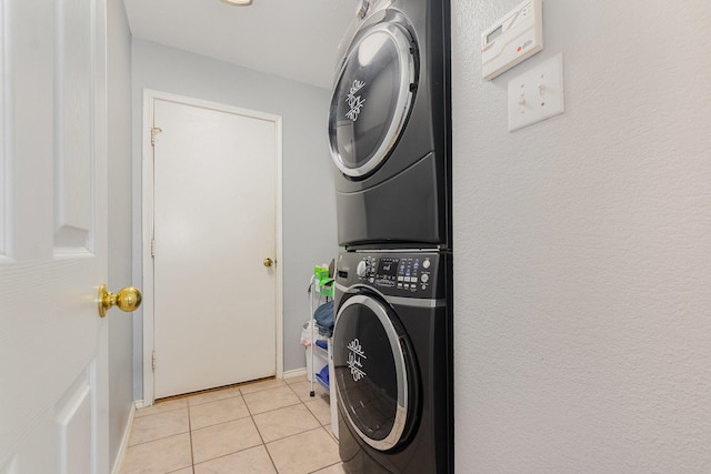 2344 Magnolia Dr, Little Elm, TX 75068 - washroom featuring stacked washing machine and dryer, light tile patterned floors, and baseboards