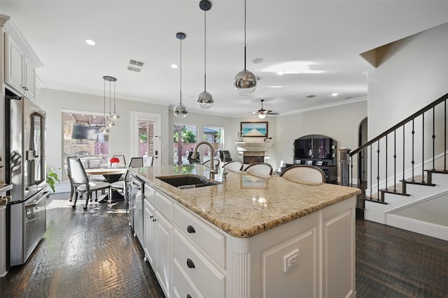 415 Fountainview Dr, Irving, TX 75039 - kitchen with stainless steel appliances, ceiling fan, a fireplace, crown molding, and white cabinetry
