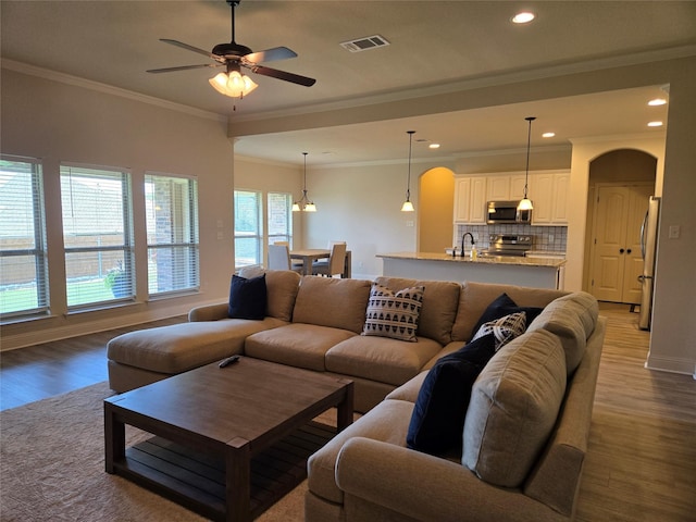 632 Yucca Ct, Aledo, TX 76008 - living area with arched walkways, wood finished floors, a ceiling fan, crown molding, and recessed lighting