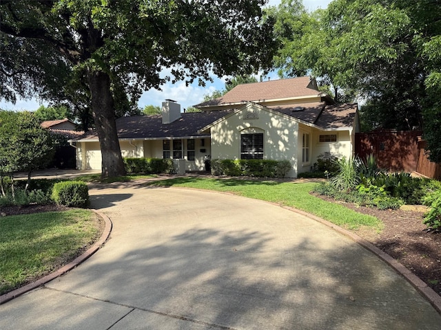 104 Crestwood Dr, Fort Worth, TX 76107 - view of front facade with curved driveway, a chimney, stucco siding, a shingled roof, and a garage