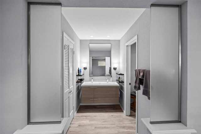 10916 Ferndale Rd, Dallas, TX 75238 - full bathroom with wood finished floors, vanity, and a closet