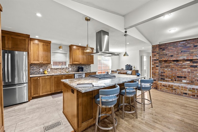 10916 Ferndale Rd, Dallas, TX 75238 - kitchen featuring appliances with stainless steel finishes, island range hood, a center island, brown cabinetry, and brick wall