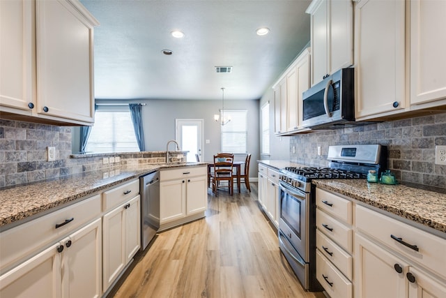 3501 Brazos St, Melissa, TX 75454 - kitchen featuring stainless steel appliances, a sink, light wood-style flooring, healthy amount of natural light, and recessed lighting