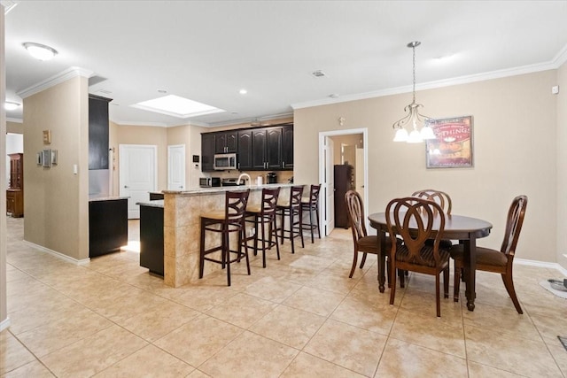 1407 Deer Hollow Dr, Arlington, TX 76002 - kitchen with stainless steel microwave, ornamental molding, a kitchen bar, light tile patterned flooring, and a chandelier