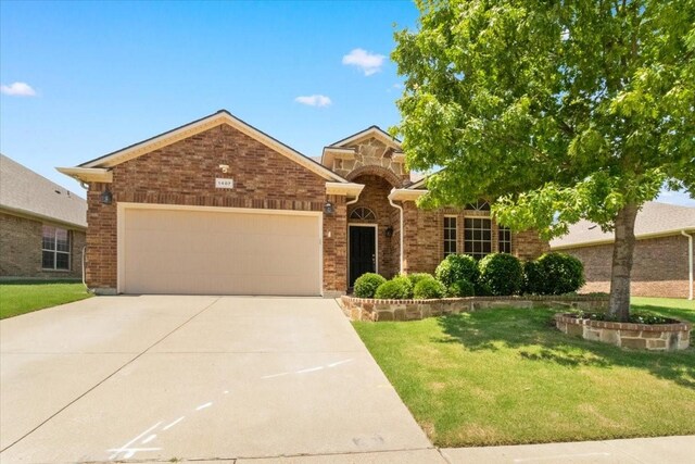 1407 Deer Hollow Dr, Arlington, TX 76002 - view of front of home with driveway, an attached garage, a front yard, and brick siding