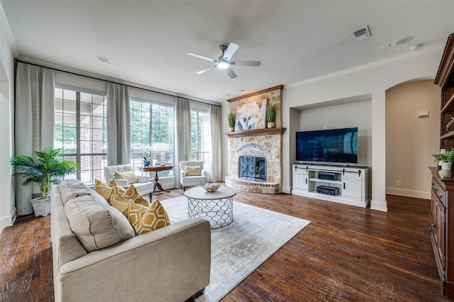 590 Willow Ridge Cir, Prosper, TX 75078 - living room featuring ceiling fan, a stone fireplace, arched walkways, plenty of natural light, and ornamental molding
