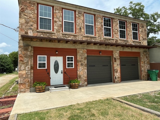 209 E Pine St, Nocona, TX 76255 - townhome / multi-family property featuring driveway, an attached garage, and stone siding
