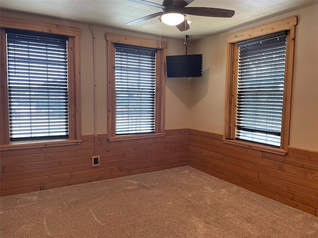 209 E Pine St, Nocona, TX 76255 - unfurnished room with carpet floors, wainscoting, ceiling fan, and wooden walls
