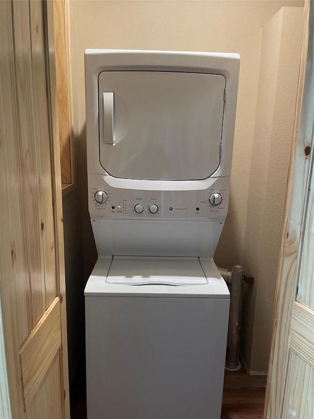 209 E Pine St, Nocona, TX 76255 - washroom with estacked washer and dryer and wood finished floors
