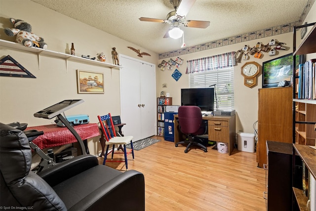 1710 Goliad Dr, Garland, TX 75042 - home office featuring a textured ceiling, light wood-type flooring, and a ceiling fan