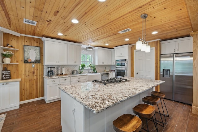 1520 Oakhurst Scenic Dr, Fort Worth, TX 76111 - kitchen with appliances with stainless steel finishes, dark wood-style flooring, a kitchen island, wood ceiling, and a sink