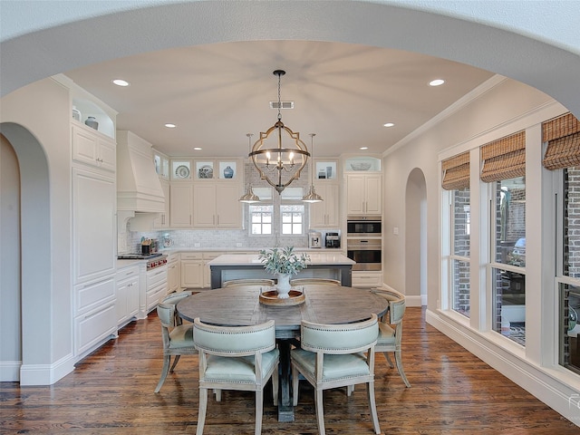 3421 Greenbrier Dr, Frisco, TX 75033 - dining space with arched walkways, ornamental molding, a chandelier, dark wood finished floors, and baseboards