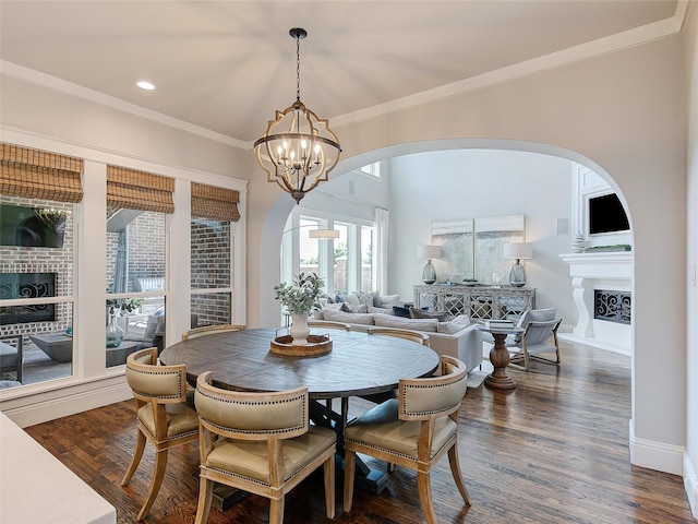 3421 Greenbrier Dr, Frisco, TX 75033 - dining space featuring ornamental molding, arched walkways, a fireplace with raised hearth, a chandelier, and recessed lighting