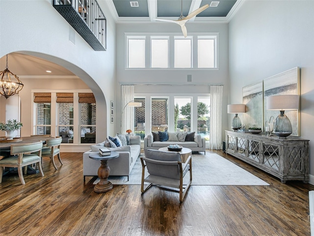 3421 Greenbrier Dr, Frisco, TX 75033 - living area with a towering ceiling, wood finished floors, ornamental molding, arched walkways, and a chandelier