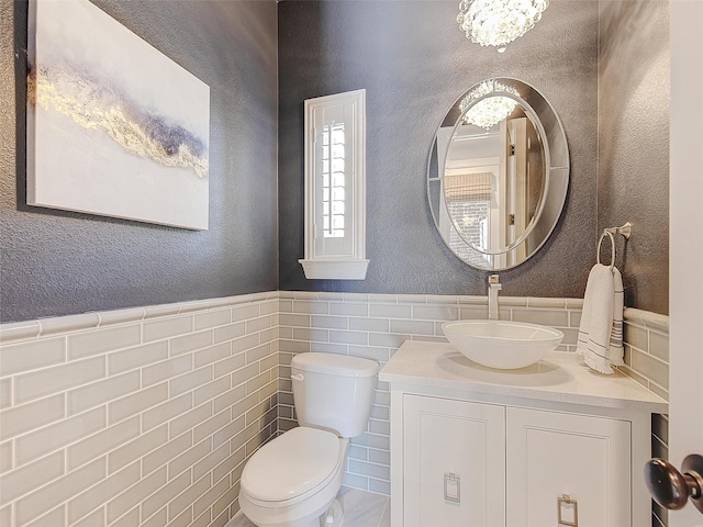 3421 Greenbrier Dr, Frisco, TX 75033 - half bathroom with toilet, vanity, wainscoting, and tile walls
