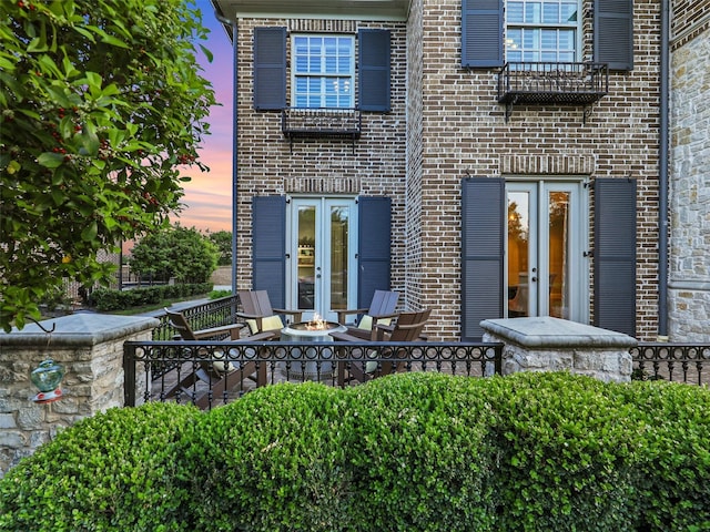 3421 Greenbrier Dr, Frisco, TX 75033 - exterior entry at dusk featuring french doors and brick siding