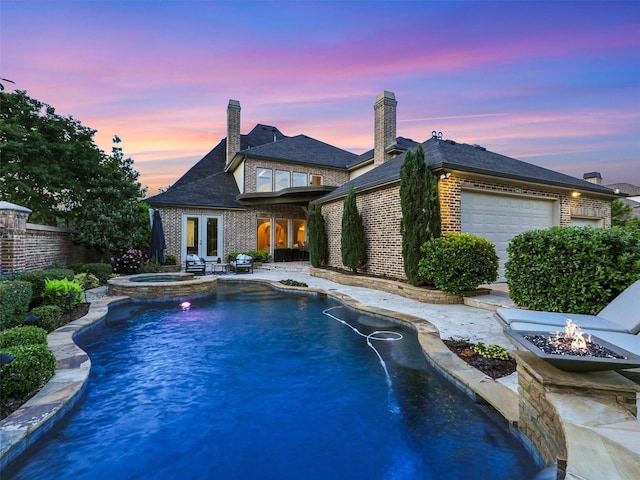 3421 Greenbrier Dr, Frisco, TX 75033 - pool at dusk featuring a fire pit, a patio area, french doors, and a pool with connected hot tub