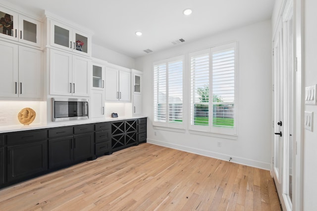 1301 Limestone Ridge Rd, Mansfield, TX 76063 - kitchen with stainless steel microwave, white cabinets, healthy amount of natural light, light wood finished floors, and recessed lighting