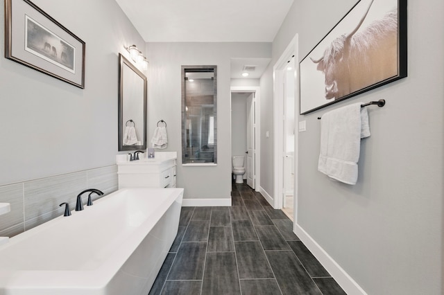 1301 Limestone Ridge Rd, Mansfield, TX 76063 - bathroom featuring a freestanding tub, vanity, baseboards, and toilet
